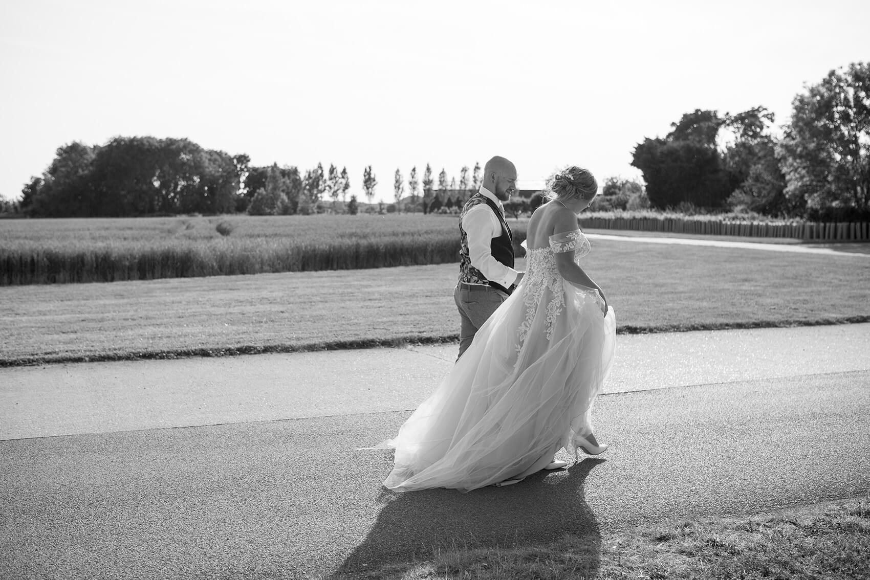 Black and white photo of the bride and groom walking.