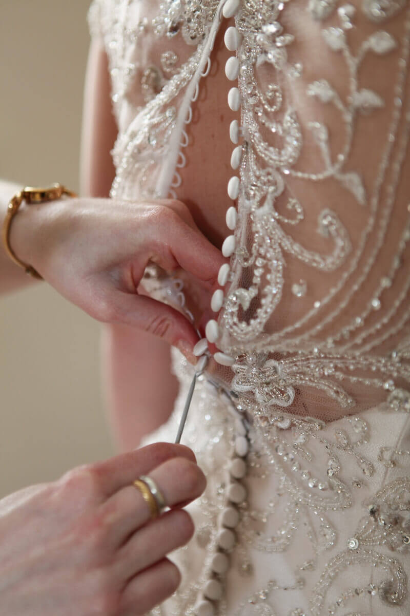 Beautiful lace details and buttons of a cream wedding dress 
