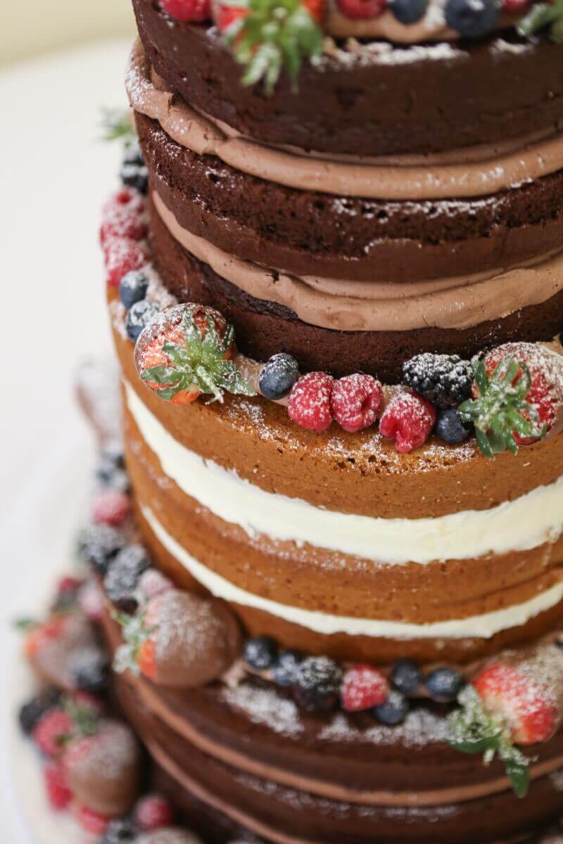Naked wedding cake with fresh fruit and chocolate. 