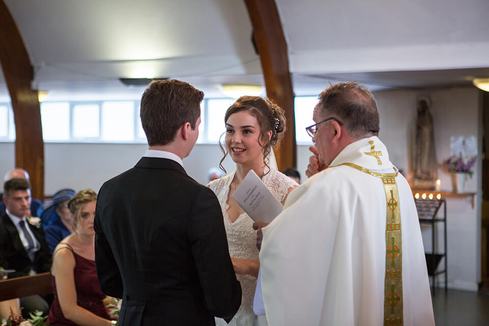 A bride smiling at her groom during the ceremony