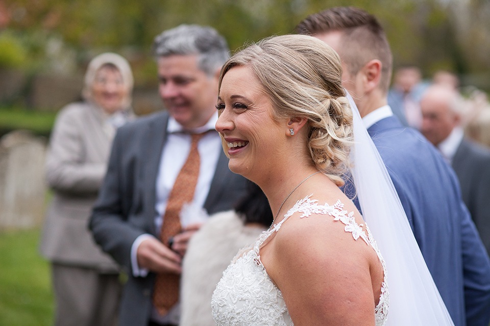 A new bride smiling happily outside a church