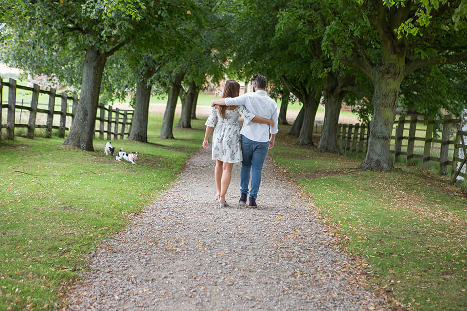 engaged couple walking down a path