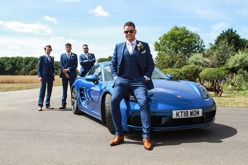 A groom sitting on a car