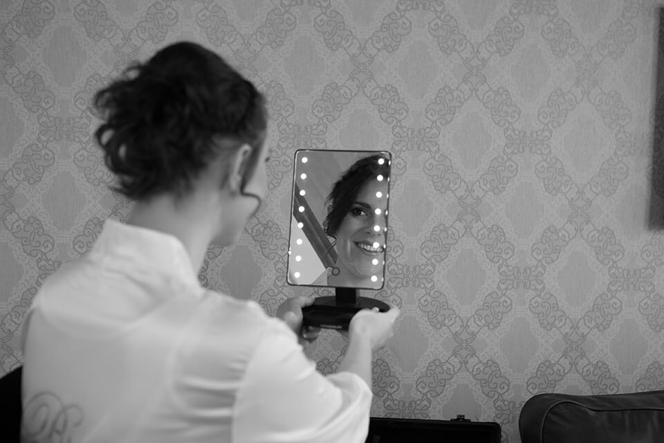 A bride smiling into a mirror