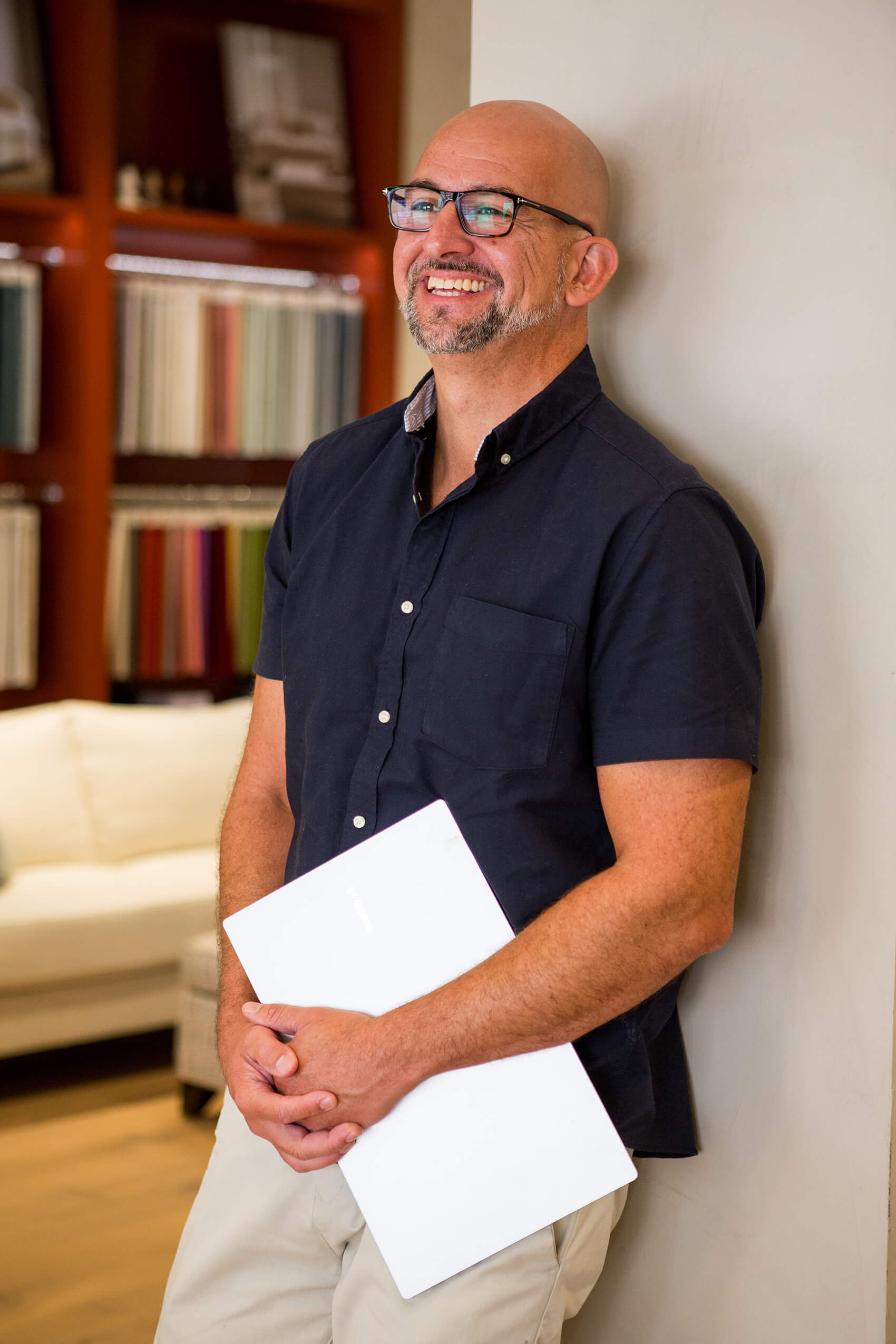 A man leaning against a wall laughing