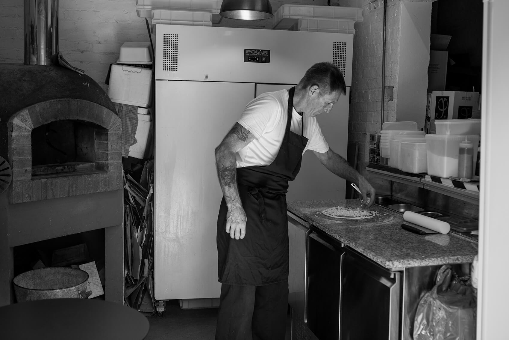 Black and white image of a chef in a kitchen cooking