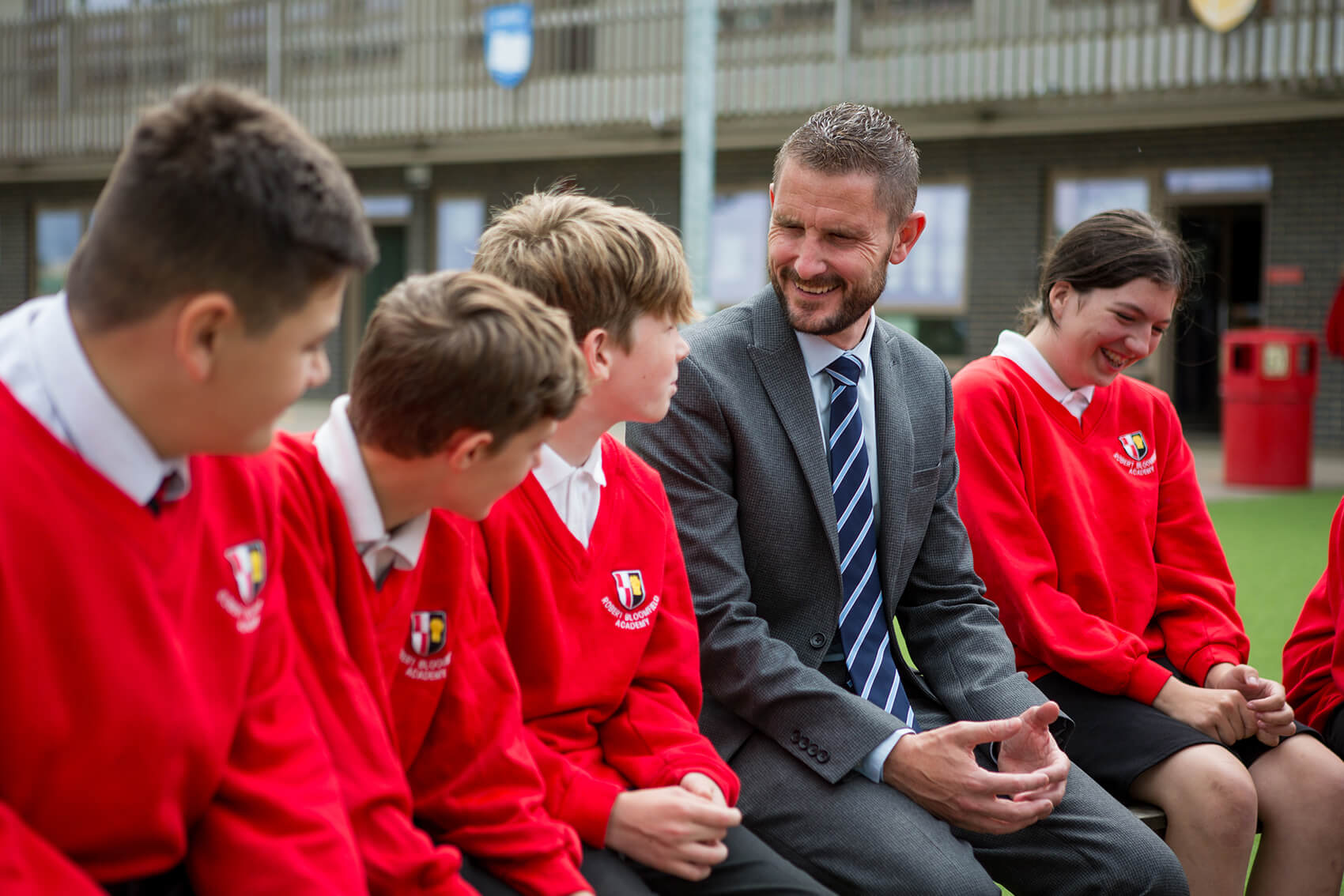 School children laughing with a teacher