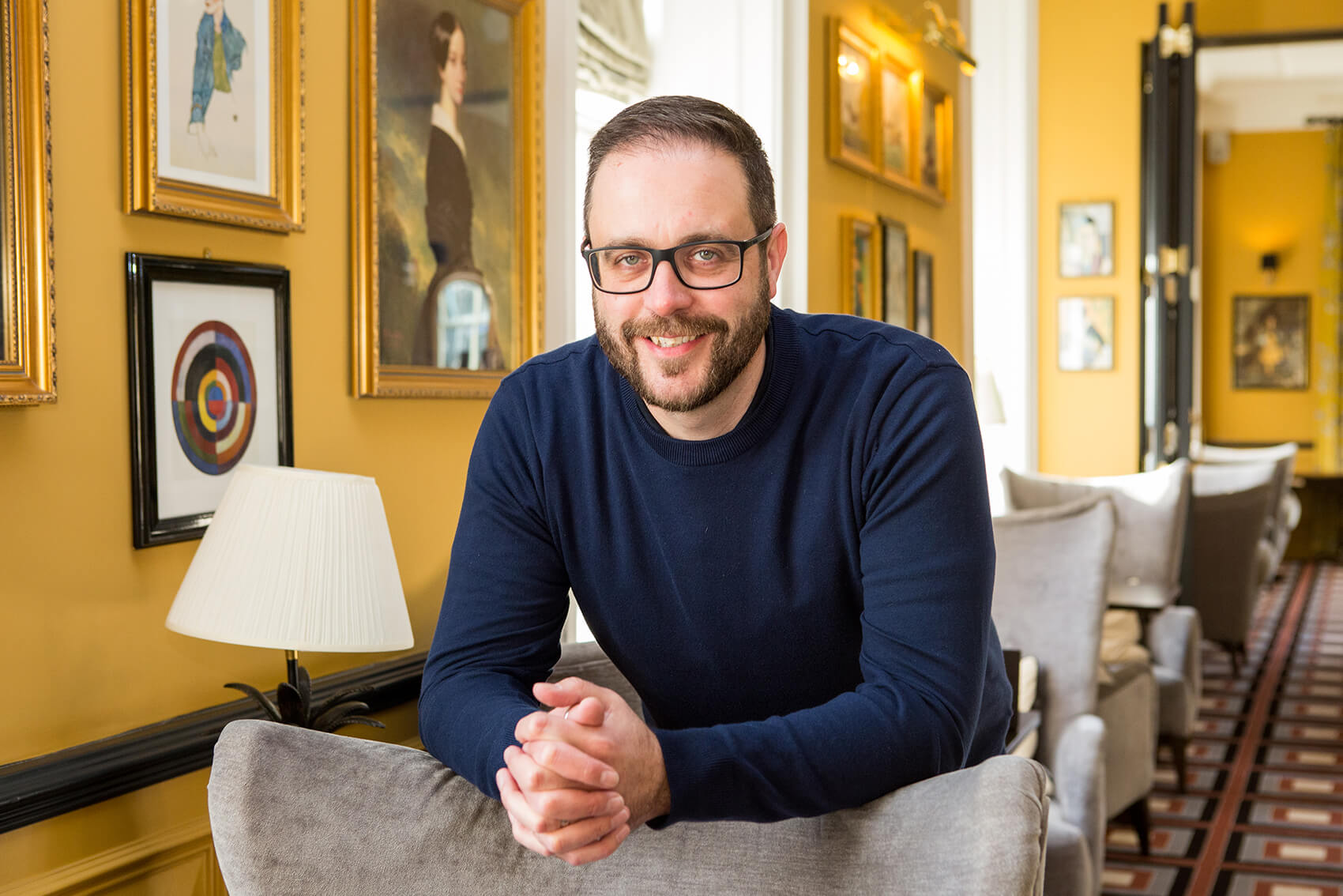 A man smiling sitting on a chair