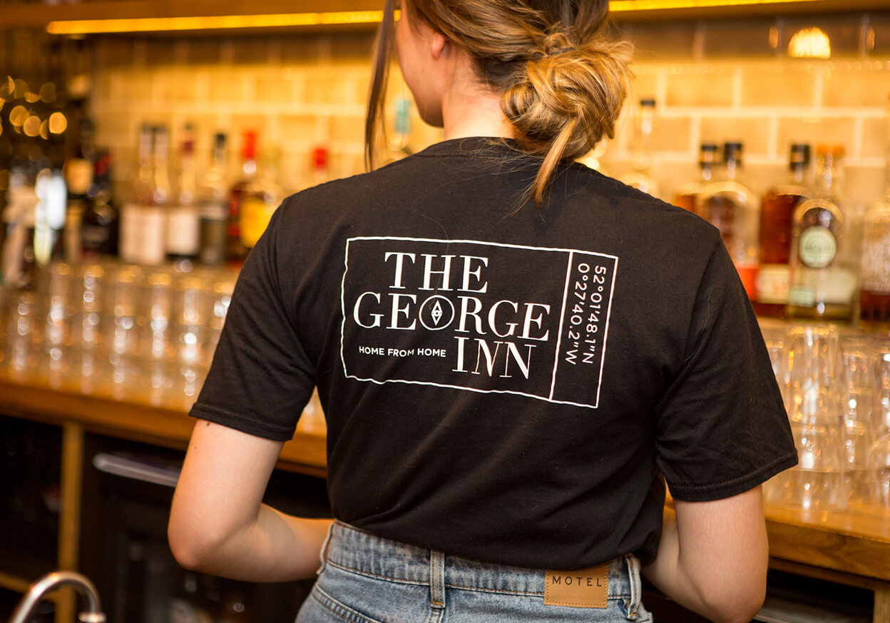 A member of bar staff working behind the bar