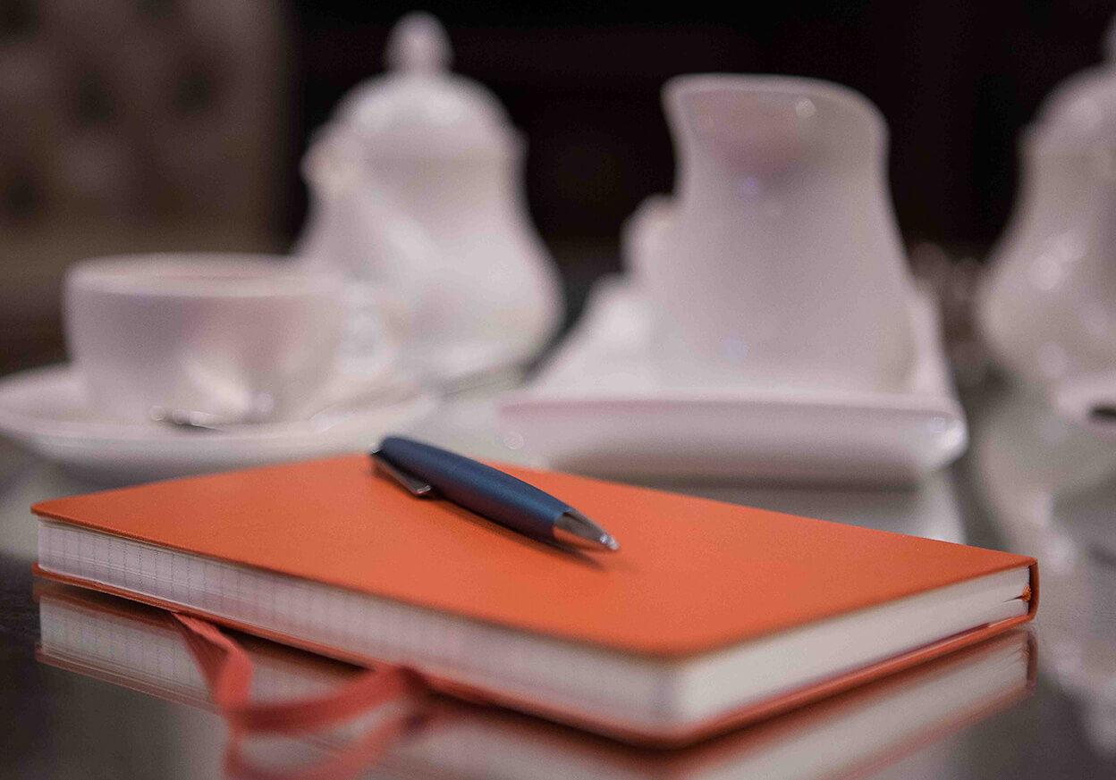 Pen atop a bold orange notebook