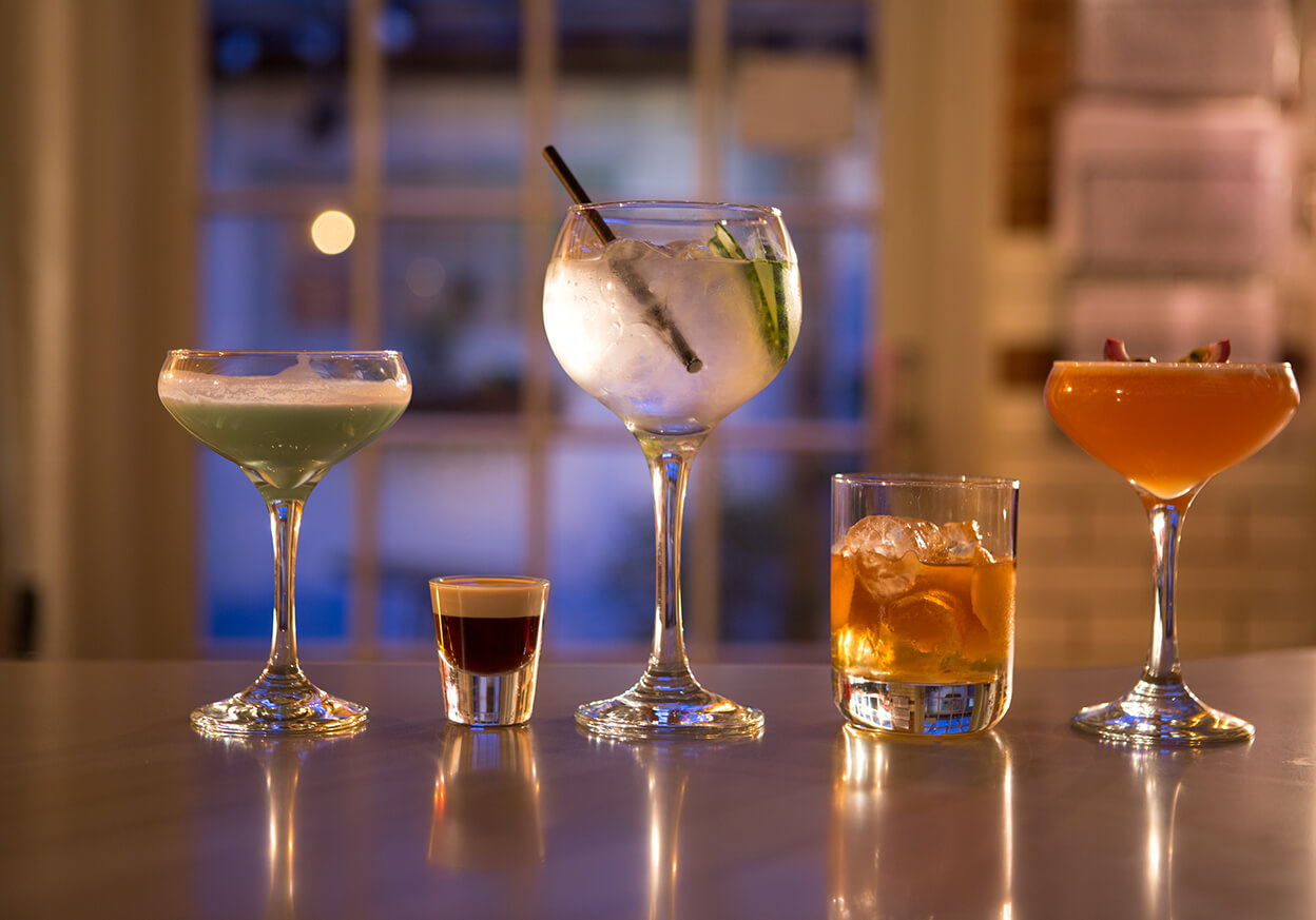 A variety of different drinks in different shaped glasses