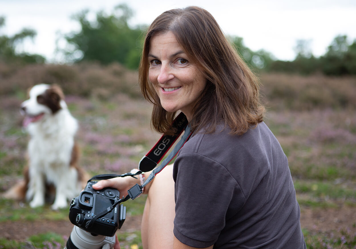 Woman taking a photograph of a dog