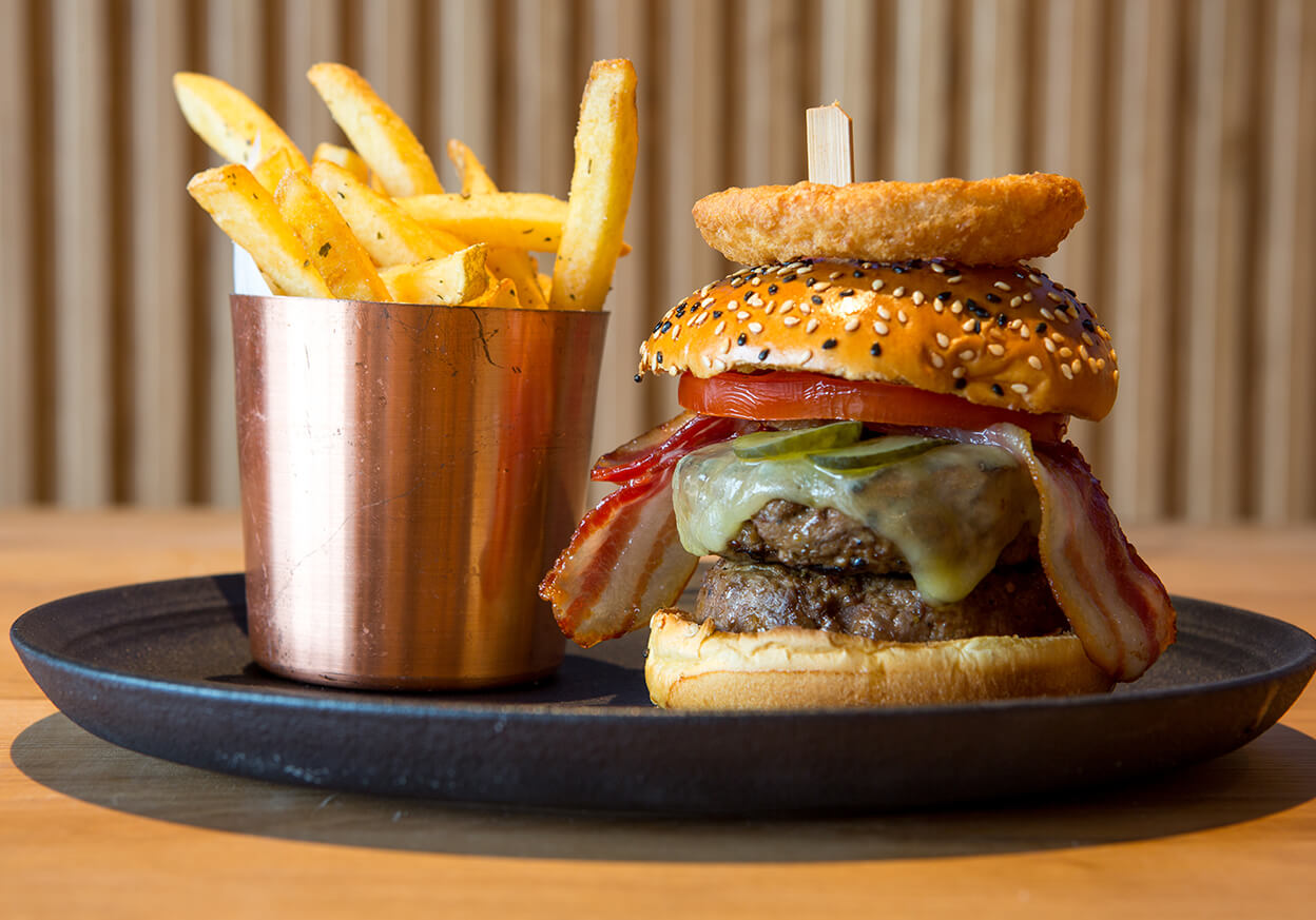 Burger and chips on a black plate