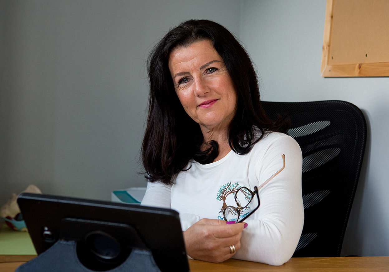 A woman with black hair smiling at a camera