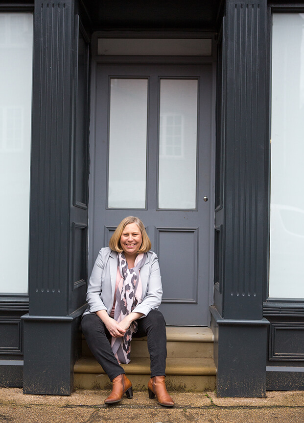 Woman sat in a grey doorway