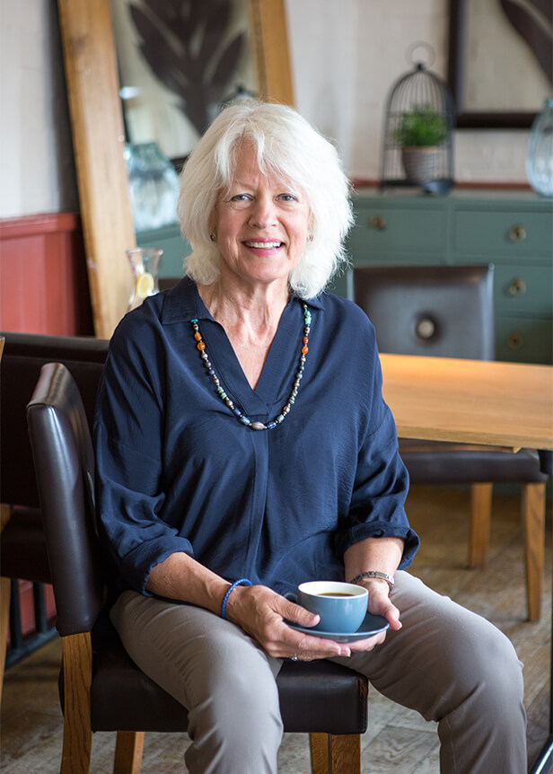 Woman sat drinking a cup of coffee