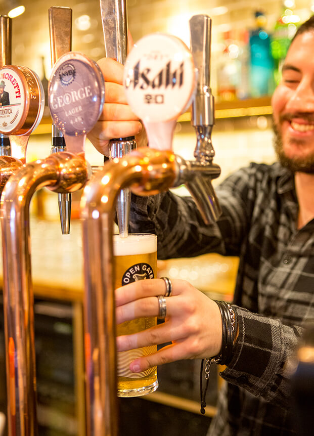 Bartender pouring a drink from the tap