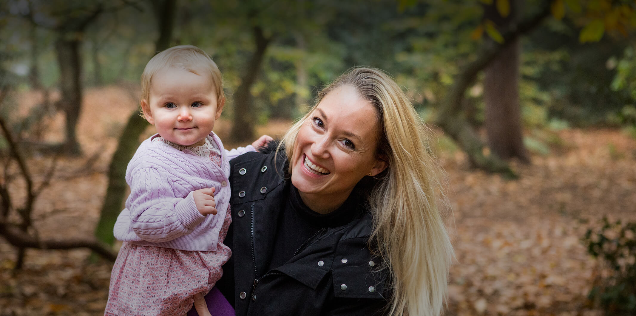 A woman holding a child and smiling