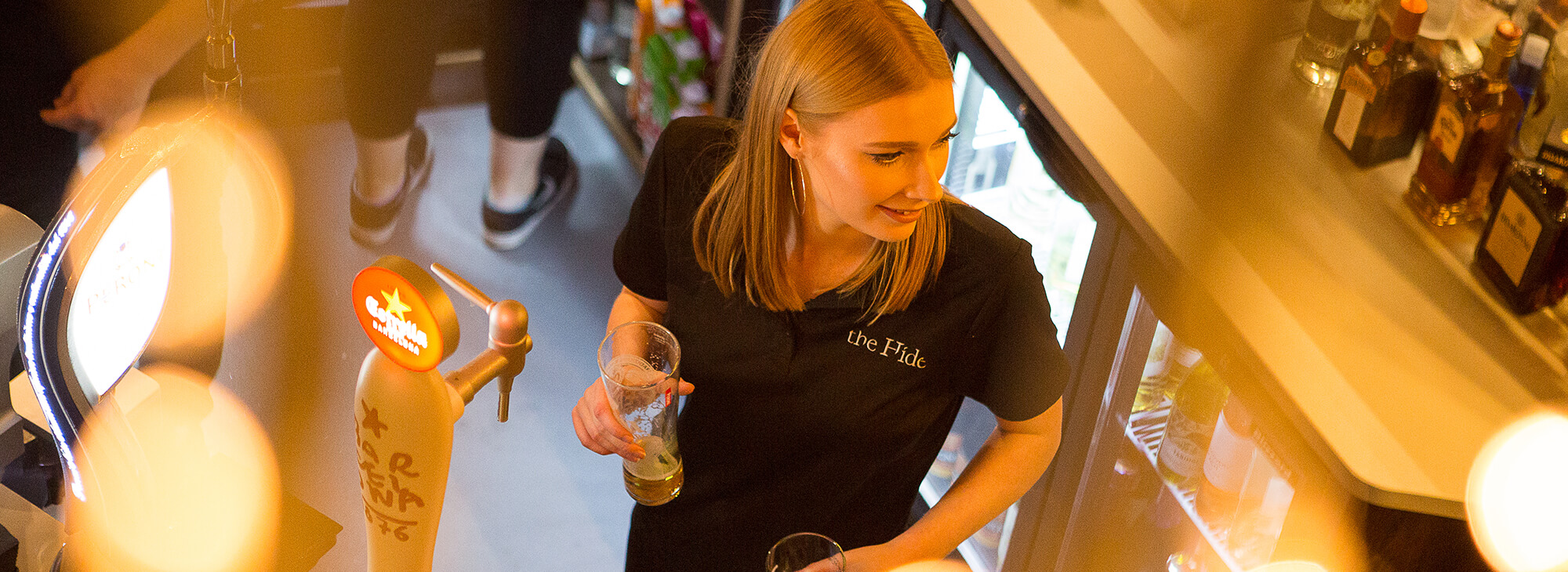 Woman pouring drinks behind a bar