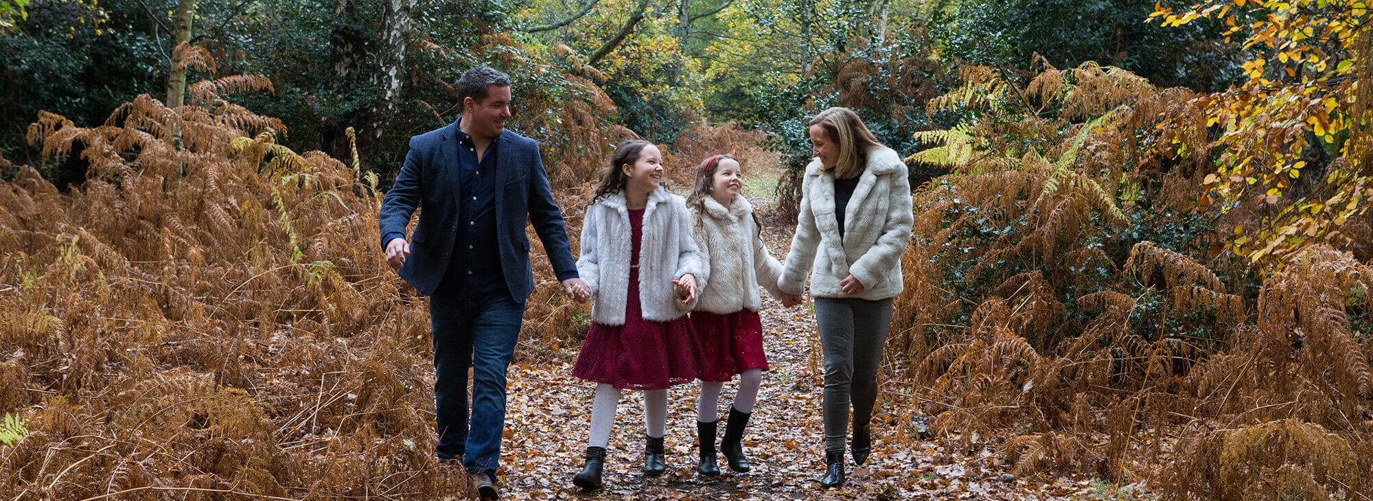 Happy family holding hands in the woods in Bedfordshire