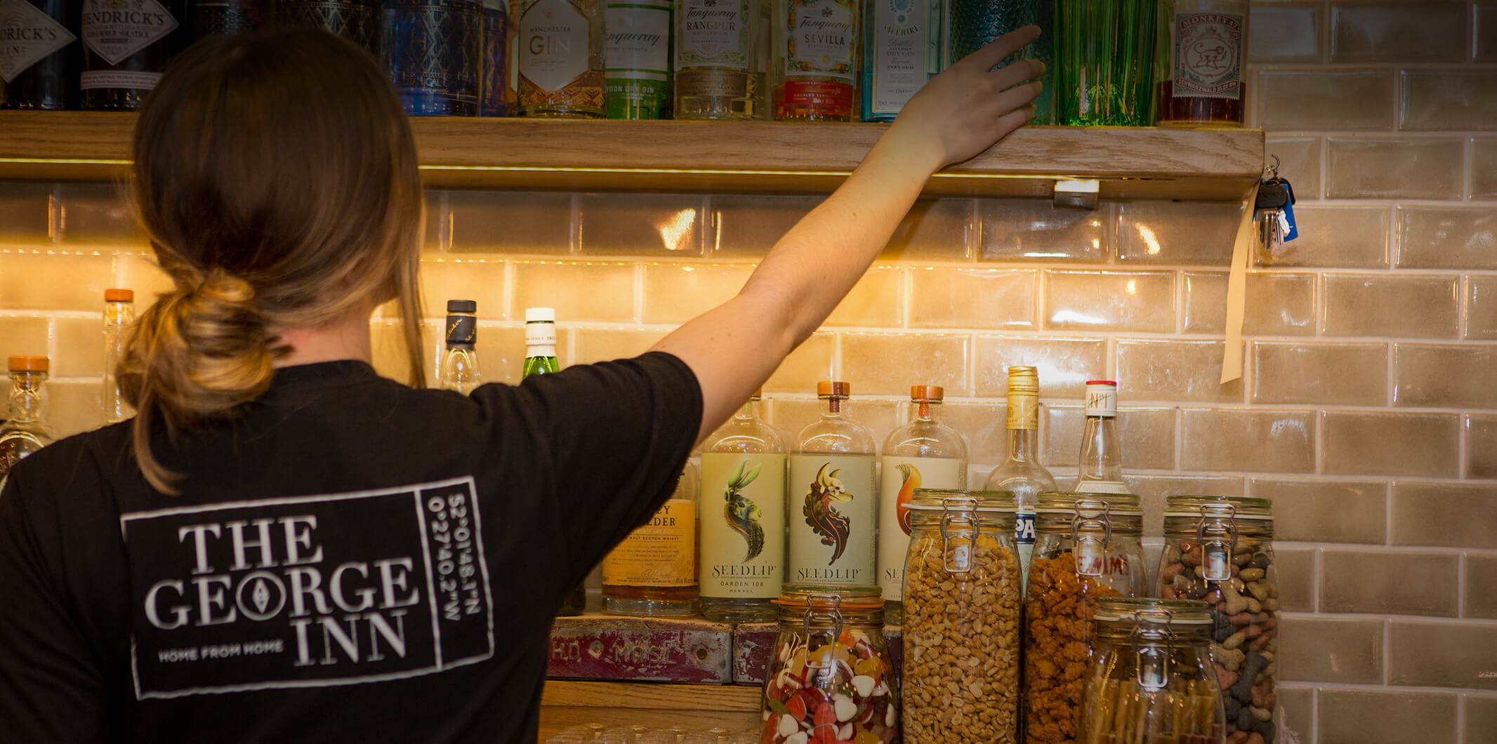 A lady picking something off the shelves at The George Inn