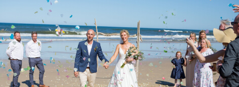 Happy newlyweds smiling with confetti being thrown