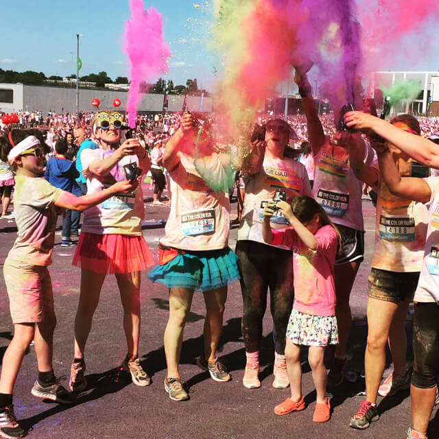 A picture of people throwing coloured powder into the air