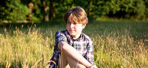 A boy sat in a field