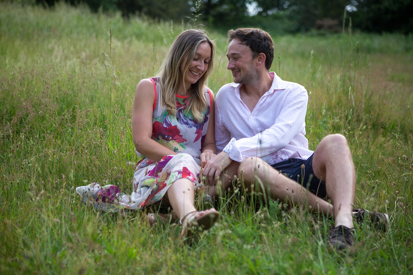 A couple sitting outside on the grass