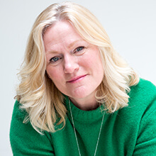 Woman in green jumper smiling at camera