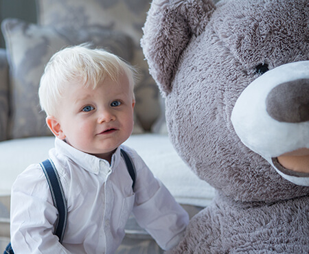 Young child sat with giant grey teddy