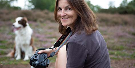 Woman taking a photograph of a dog