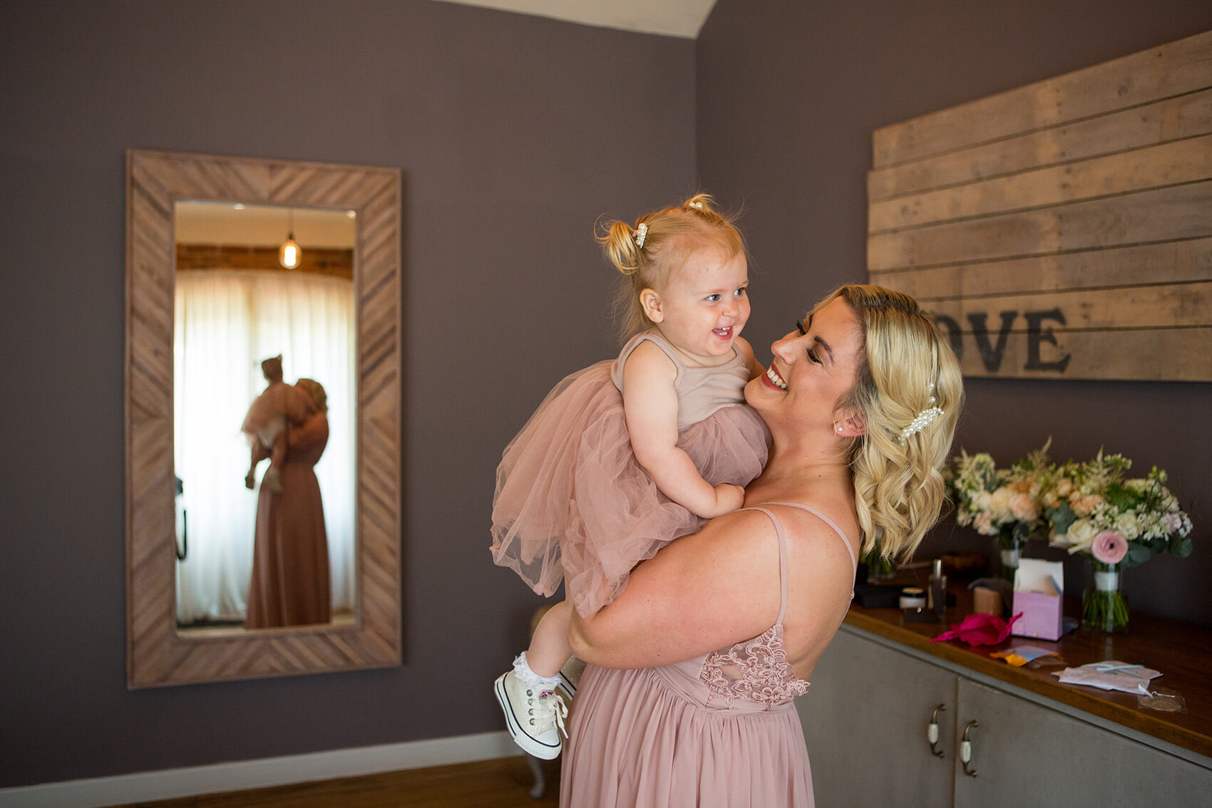 Bridesmaid holding a small child