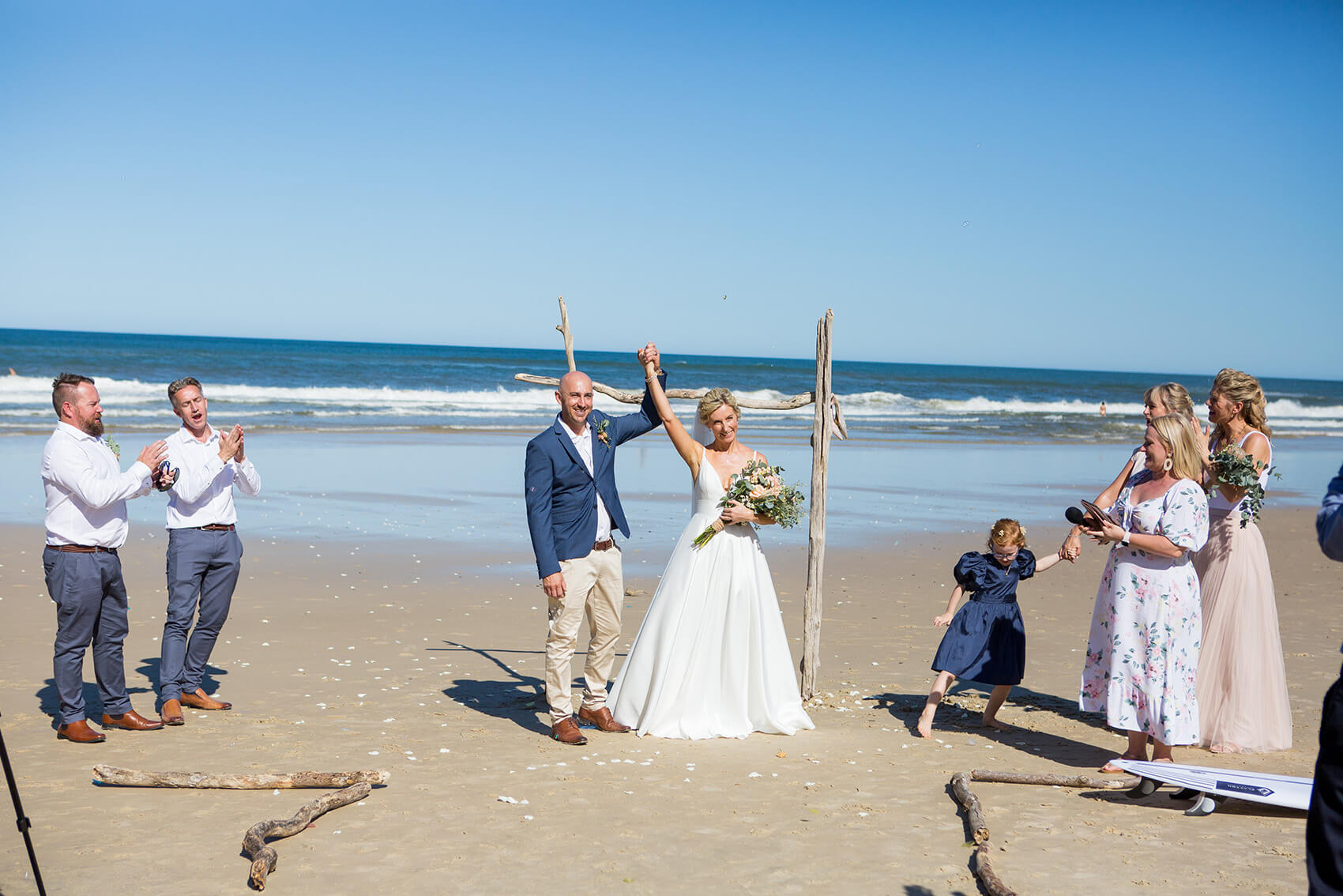 Bride and groom holding hands on the beach