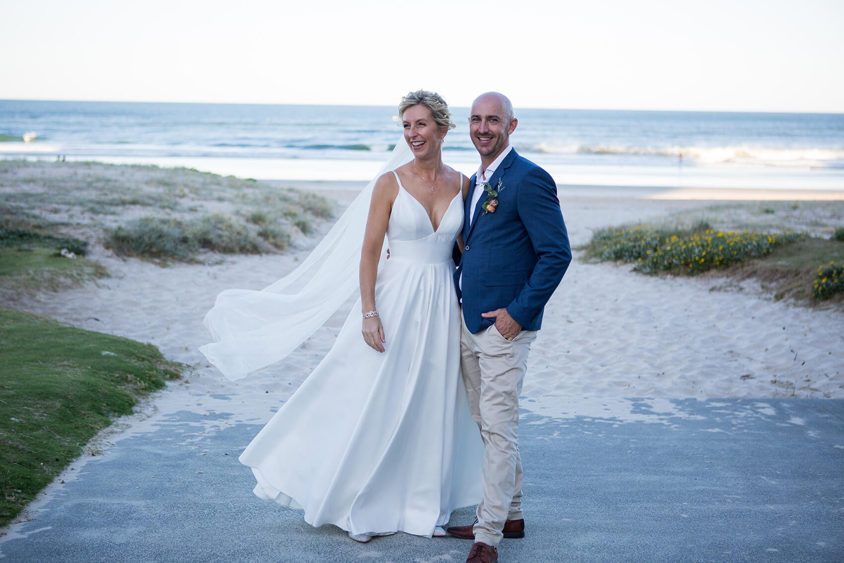 Bride and groom smiling on the beach