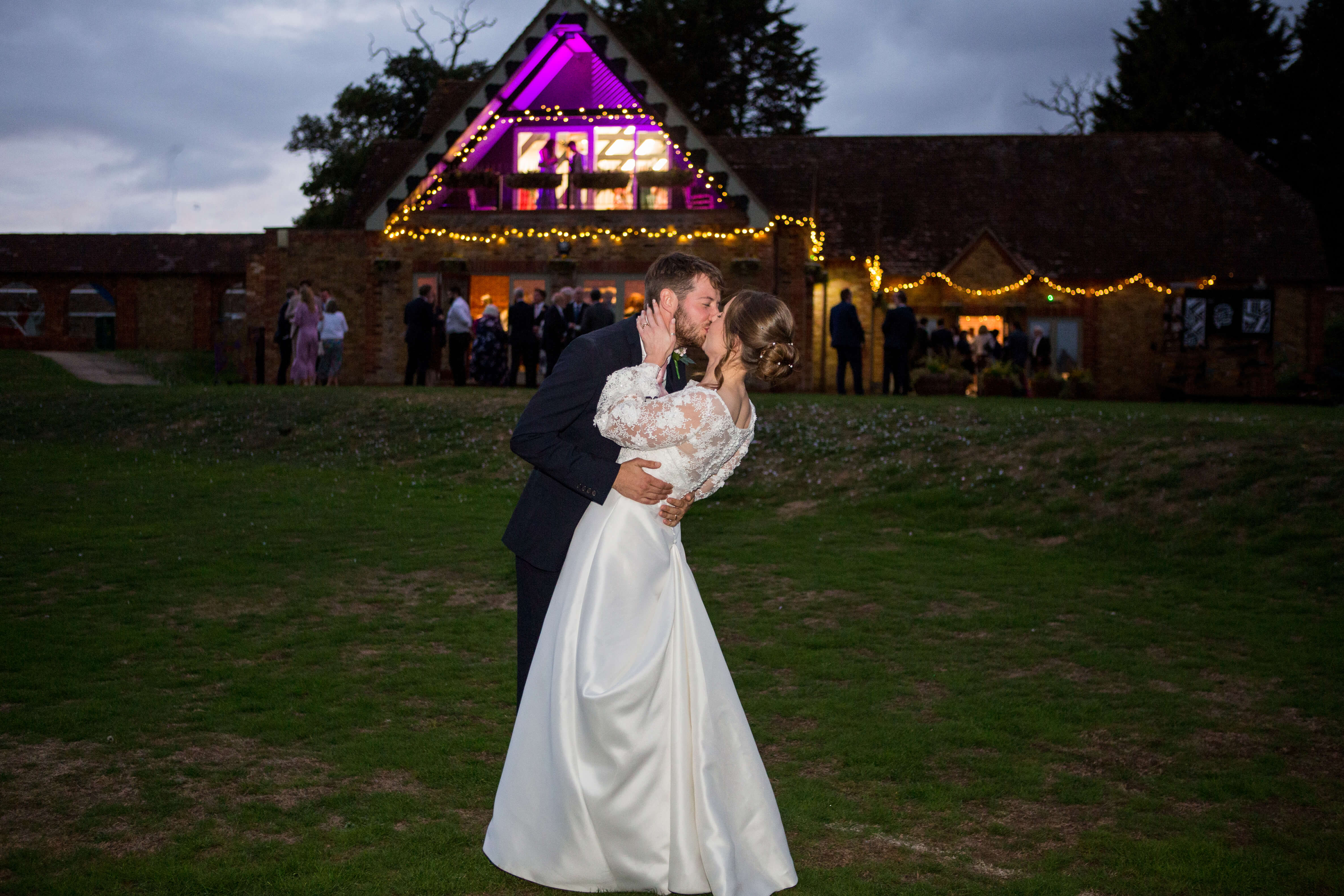 Bride and groom kissing in front of the wedding venue
