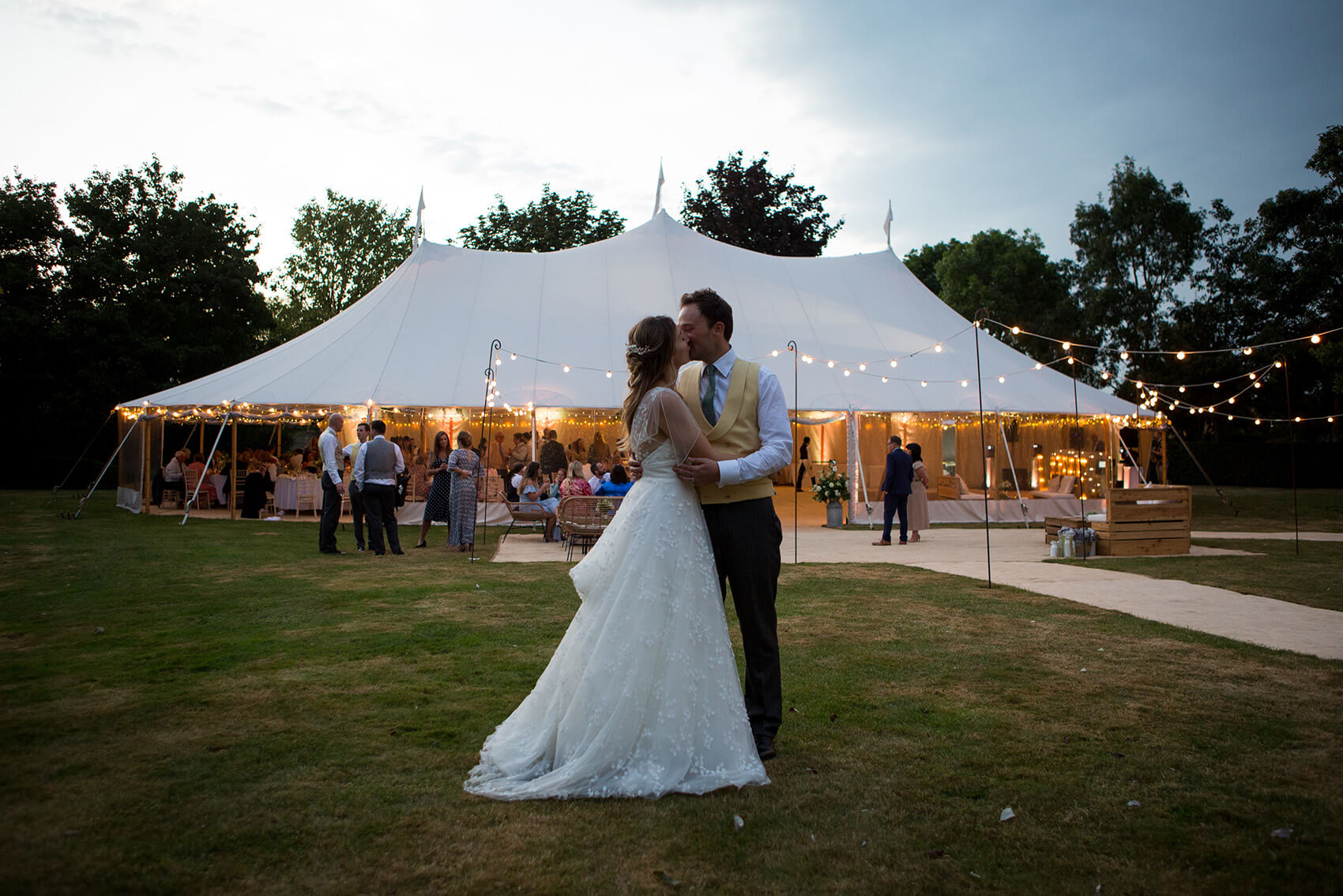 Bride and groom standing in front of a tent