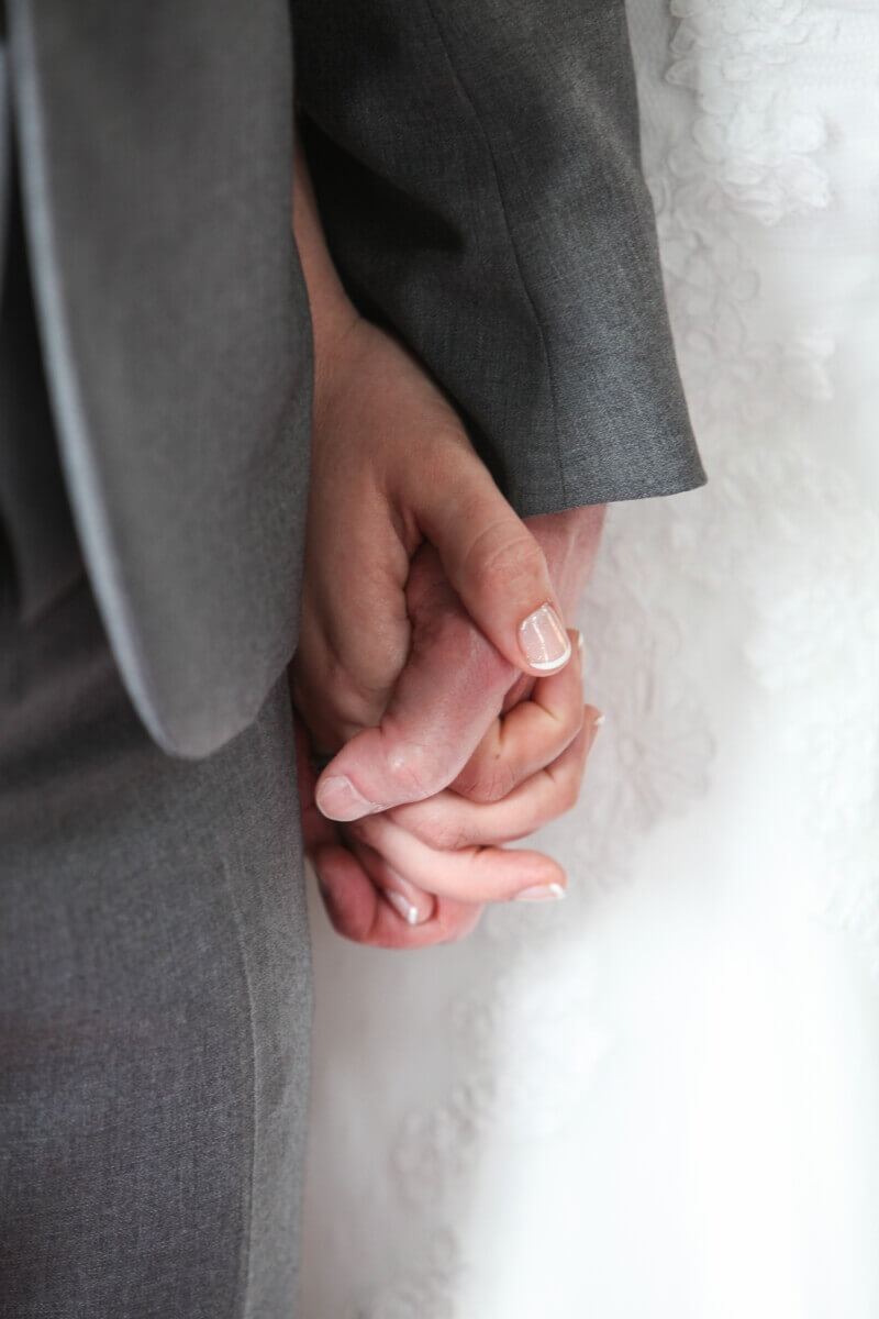 Bride and groom holding hands at St Andrews Church in Ampthill Bedfordshire