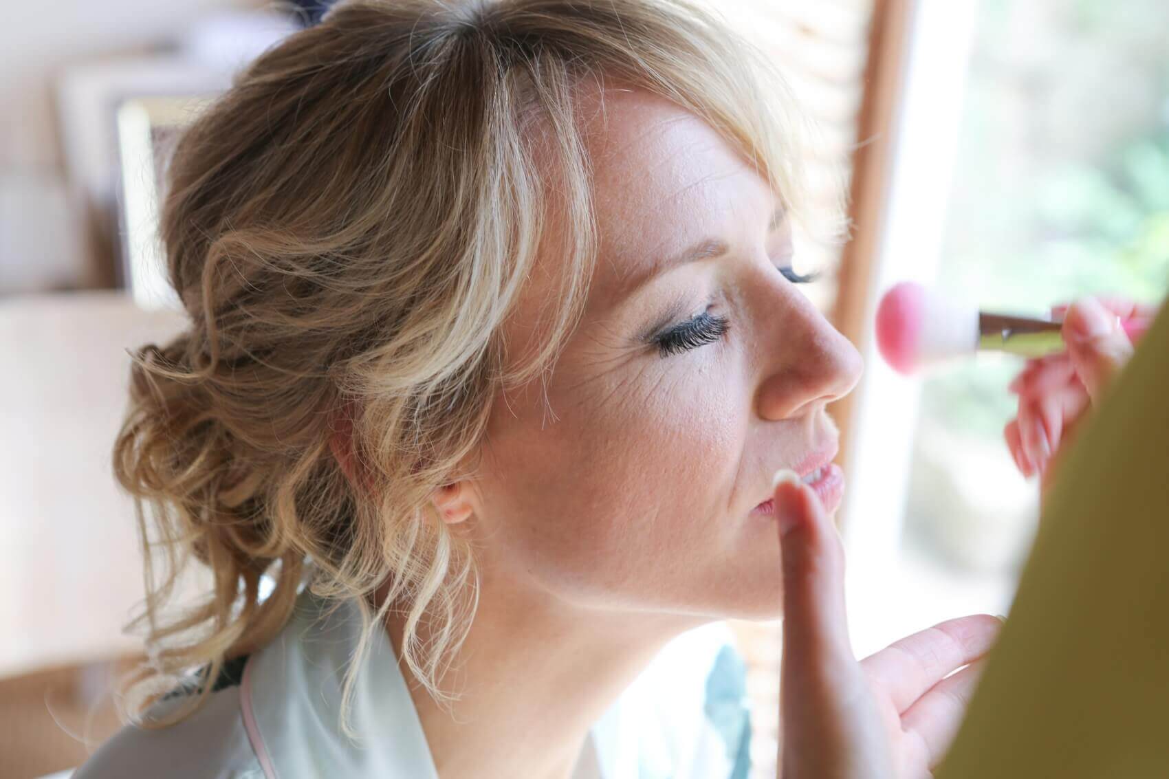 Bride having wedding make up put on at Tofte Manor Sharnbrook