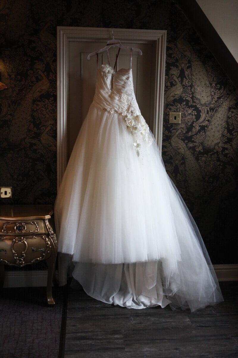 Wedding dress hanging up waiting for the bride to put it on for her spring wedding day. 