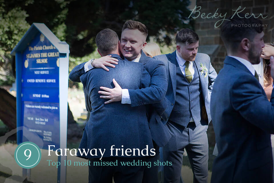 Two friends at a wedding hugging
